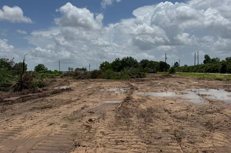 A graded lot holding standing water between tyre ruts