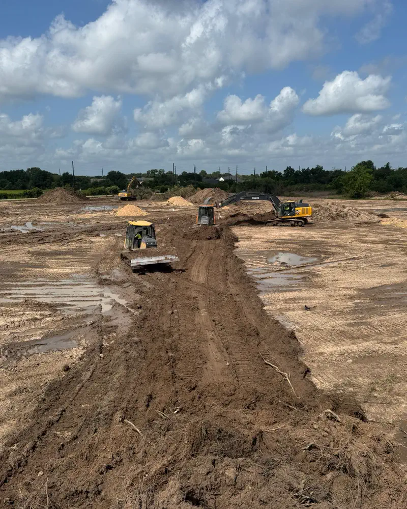A dozer and excavators working across a site under construction